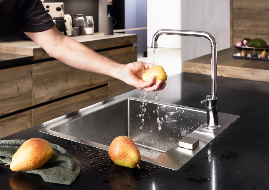 Apfel wird an Kuechenspuele gewaschen Apfel wird an Kuechenspuele gewaschen